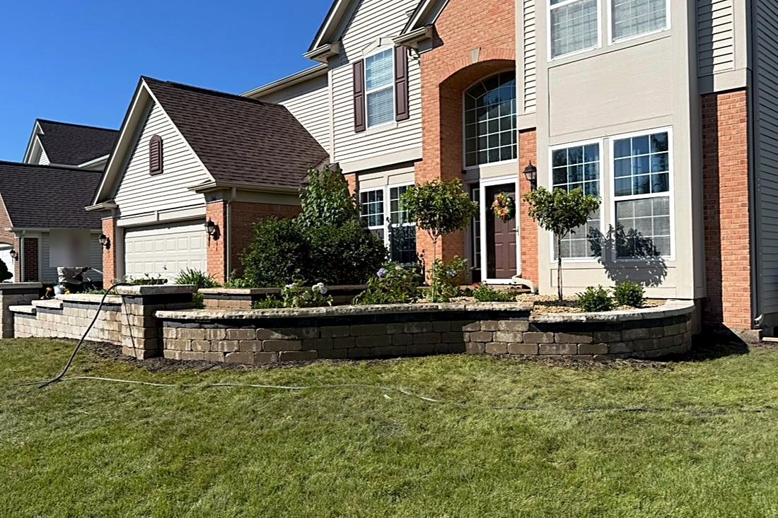PH Landscape crew finishing a front entry seat wall and planting bed on a Fox Valley home