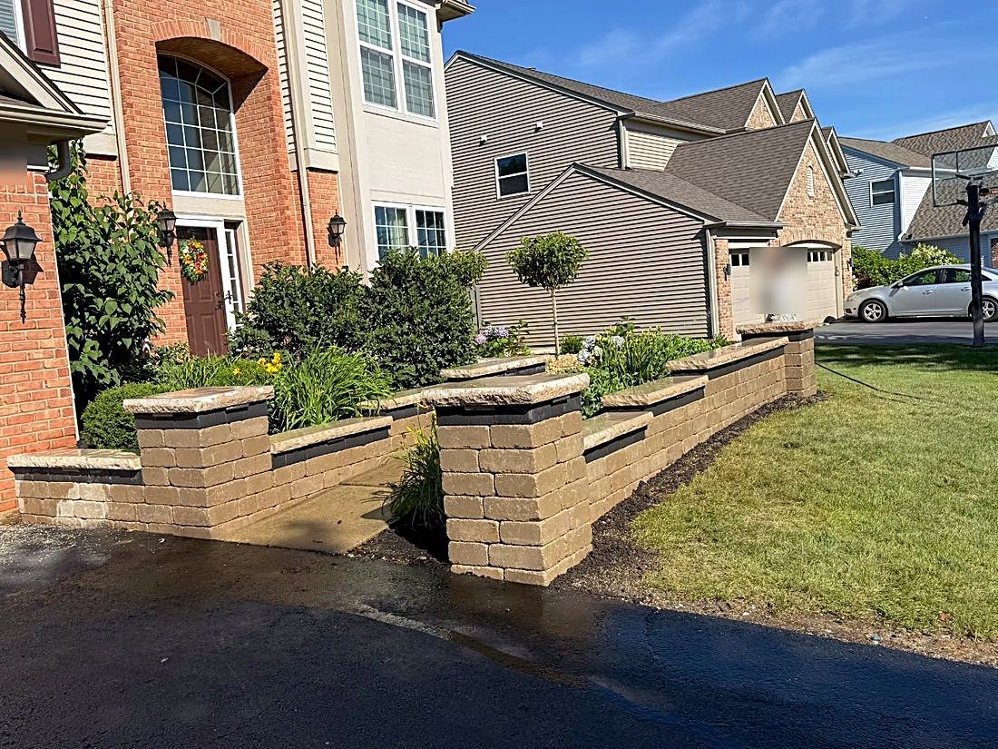 Terraced segmental block retaining wall with capped pillars and planted beds, installed in Naperville, Illinois